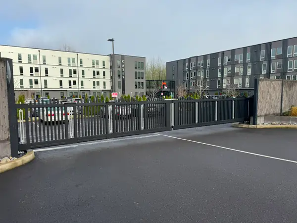 Black metal cantilever slide gate securing apartment parking lot at Casey building
