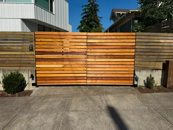 Horizontal cedar slat automatic driveway gate with keypad, sunlit